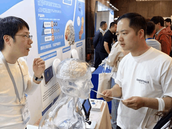 工作人员介绍全脑近红外脑功能监测系统。新京报记者 陶冉 摄