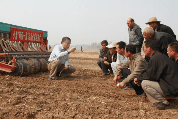 王法宏研究员在田间培训小麦播前播后镇压技术。