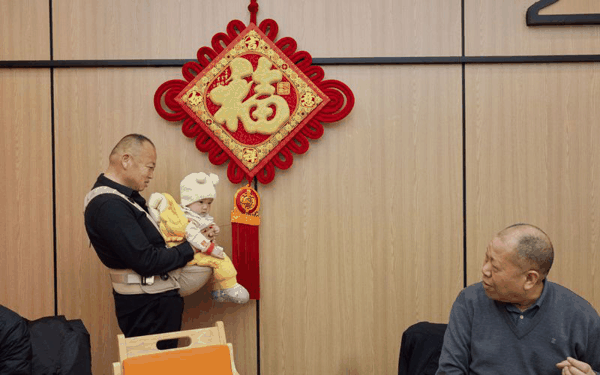 父母餐厅内，一名顾客在福字前一边哄孩子，一边跟街坊邻居聊天。新京报记者 郭延冰 摄