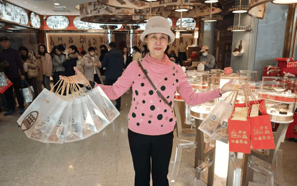 2月12日，北京稻香村零号店寻宝馆，游客郑女士购买了多份总书记同款年味小食。 新京报记者 郭铁 摄