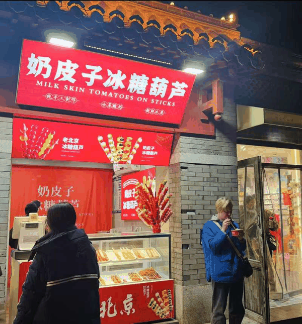 外国游客在南锣鼓巷品尝蟹黄汤包。新京报贝壳财经记者王真真 摄