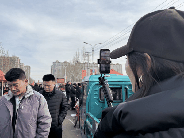 2月16日，农历腊月二十九早上八点左右，临沭县曹洼大集，一位主播正在直播赶集。 新京报记者 赵敏 摄