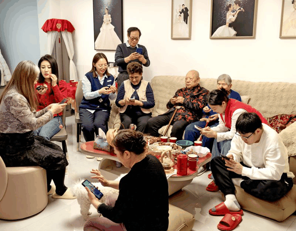 ▲2月16日除夕夜，北京某市民一大家，围坐在电视机前看春晚、抢红包。图/IC photo