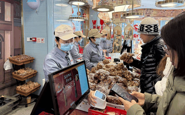 2月20日，北京稻香村门店，市民游客在购买总书记同款年货“三件套”。新京报记者 陈琳 摄