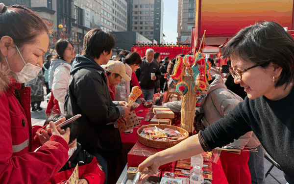 2月20日，隆福寺新春市集，游客在购买“翻里花”。新京报记者 陈琳 摄