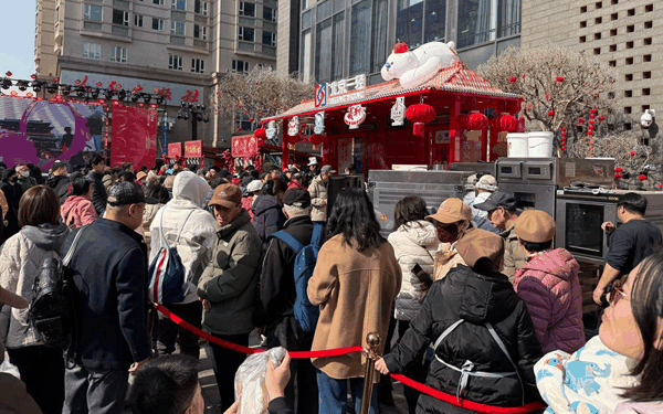 2月20日，隆福寺新春市集，排队购买义利面包的顾客从摊位排进了隆福大厦。新京报记者 陈琳 摄
