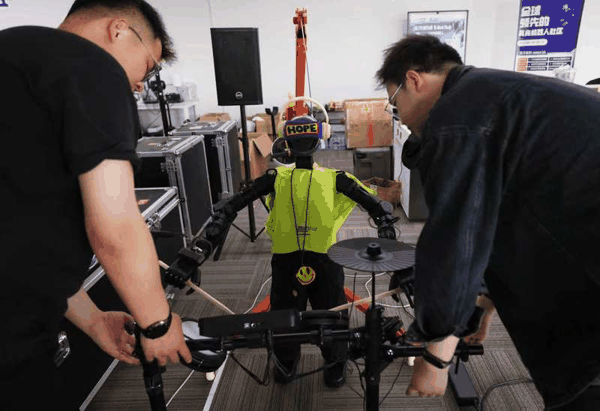 工作人员调试机器人乐手。新京报记者 李木易 摄