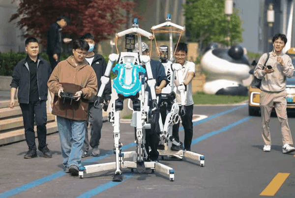 工作人员席地而坐调试参赛机器人。新京报记者 李木易 摄