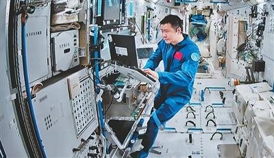 在北京航天飞行控制中心屏幕上拍摄的陈冬在空间站组合体舱内工作画面。新华社记者 李明刚摄