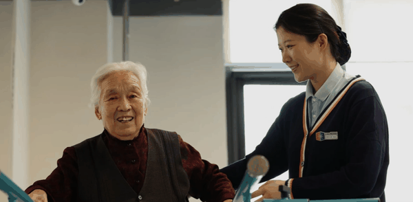 徐传艳（右）帮助老人做康复训练。受访者供图