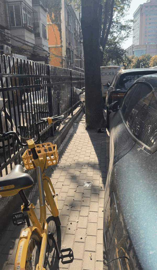黄瓜园路南侧也有黄线划出的人行道，上面停满了车。新京报记者 陈璐 摄  