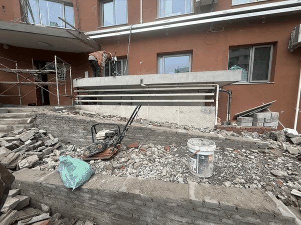 4月17日，朝阳区东大桥东里12号楼单元门前，工人正在拆除“之”字形坡道。新京报记者 曹晶瑞 摄