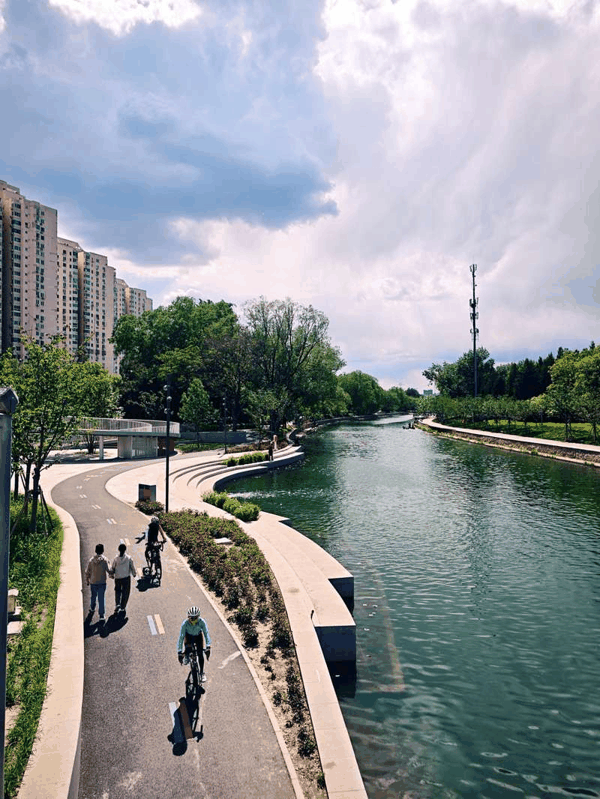 两名骑行者在北小河边骑行。