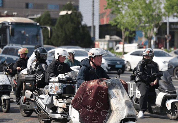 从今早的路面情况来看，约八成左右的电动车骑行者都能自觉佩戴好安全头盔。新京报记者 王贵彬 摄