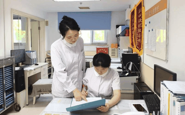 赵芳（左）与同事正在核对工作内容。受访者供图