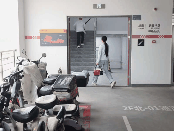 市民停放电动自行车后通过“空中连廊”直接进入地铁站乘车。新京报记者 王贵彬 摄