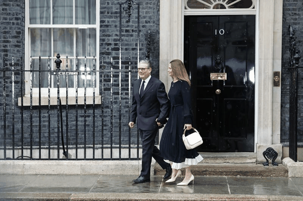 当地时间2026年5月13日，英国伦敦，英国首相斯塔默和妻子启程，前往参加英国国会开幕大典。图/IC photo