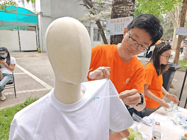 中国科学院理化所志愿者演示不沾水的衣服。新京报记者 张璐 摄