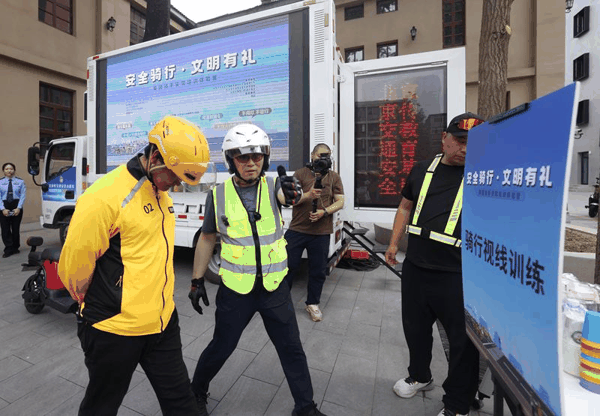 外卖骑手在模拟低头骑行。新京报记者 王贵彬 摄