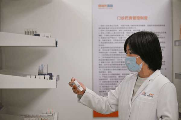 医护人员在天津鹏瑞利医院门诊药房查看药品。新华社记者　李然　摄