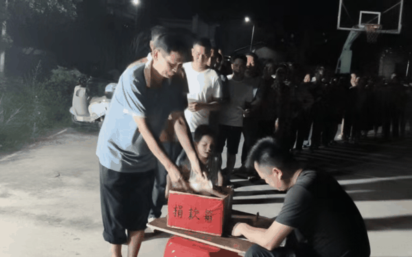 村民们在篮球场排队捐款。 受访者供图