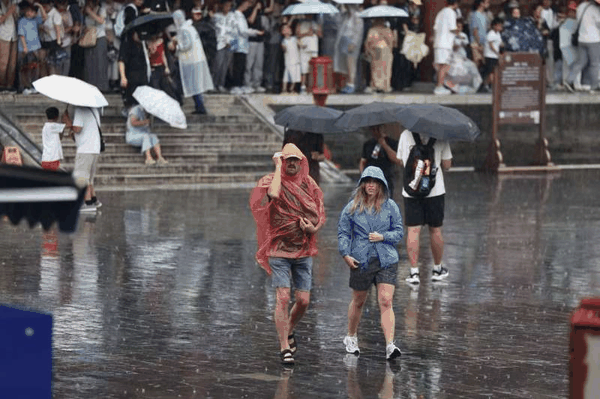长椿街，市民在大雨中骑行。