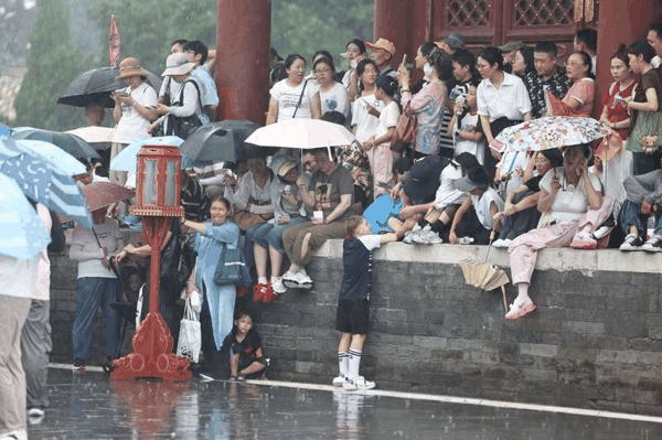 长椿街，市民在大雨中骑行。