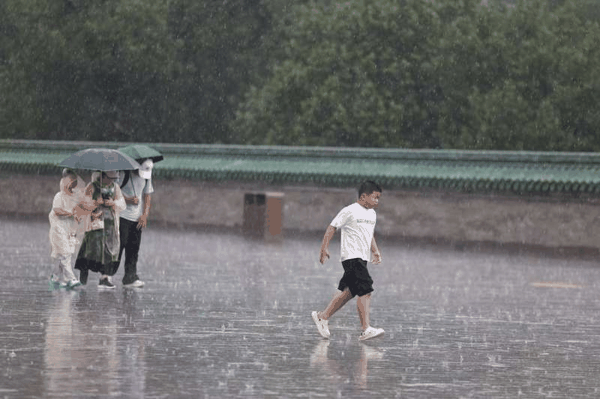 长椿街，市民在大雨中骑行。