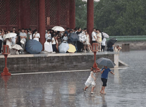 长椿街，市民在大雨中骑行。