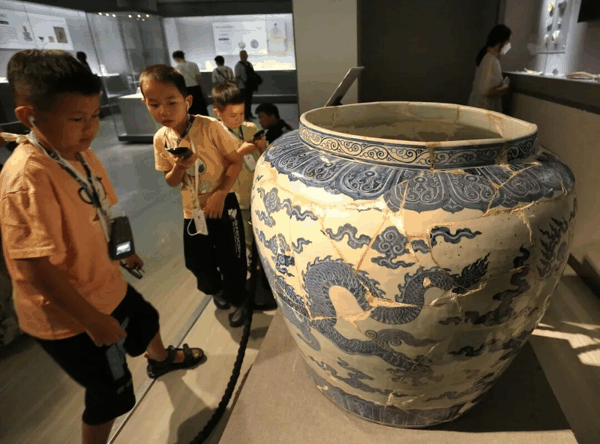 ​小朋友在参观修复完整的明代“青花大龙缸”。图片来源：视觉中国