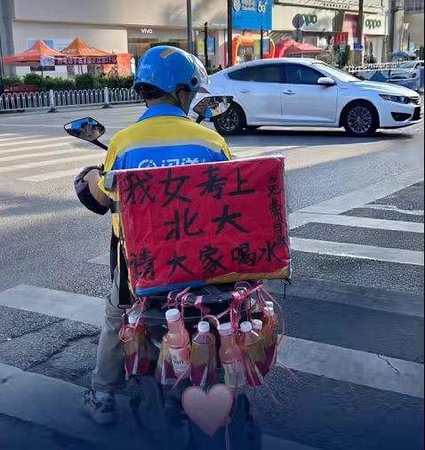 ▲闪送员李师傅在电动车后挂满饮料请大家免费喝，庆祝自己女儿考上北京大学。图/潇湘晨报