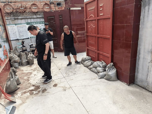 8月11日，房山启动防汛一级加强应急响应后，平峪村村干部在整理沙袋。受访者供图