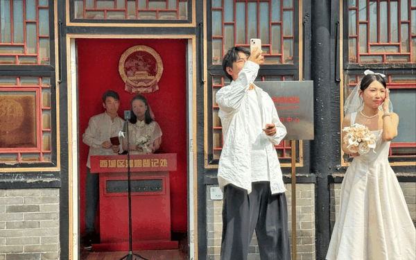 新人在护国观音寺户外登记点等待办理结婚证。新京报记者 王贵彬 摄