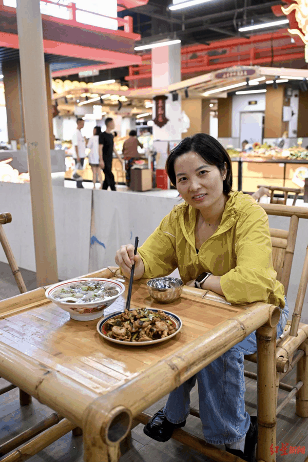 ▲市民邓煦在菜市场内享用新鲜出炉的炒菜