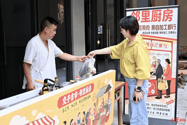 ▲市民邓煦在菜市场买了菜后交给罗师傅进行烹饪
