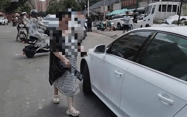 ▲女车主取下前车牌放进车内。图/贵州广电百姓关注