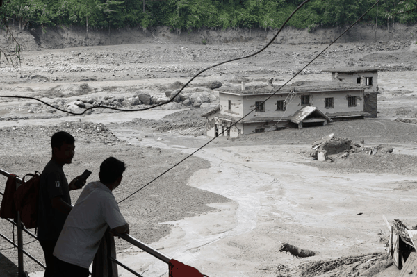 ▲当地时间2026年8月26日，尼泊尔努瓦果德县，人们在特里舒利集市观看洪水席卷街道 图据视觉中国