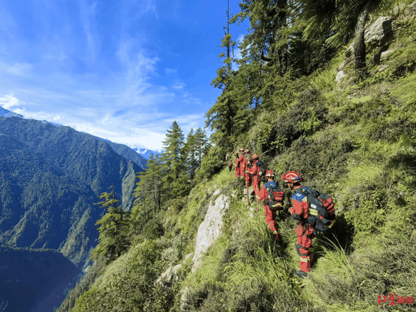 ▲来自成都的消防救援第一梯队队员翻山越岭徒步，崖壁索降挺进核心区。郑礼军 摄