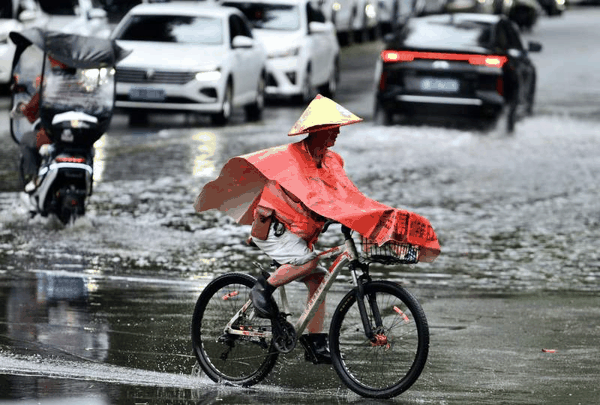 9月3日，今年第18号台风“沙德尔”登陆，福州市民骑车经过积水路段。图/IC 
