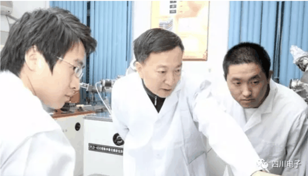 ▲李言荣院士（中）在实验室中 图据四川省电子学会