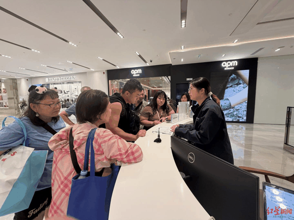 ▲境外游客在IFS离境退税“即买即退”集中退付点咨询