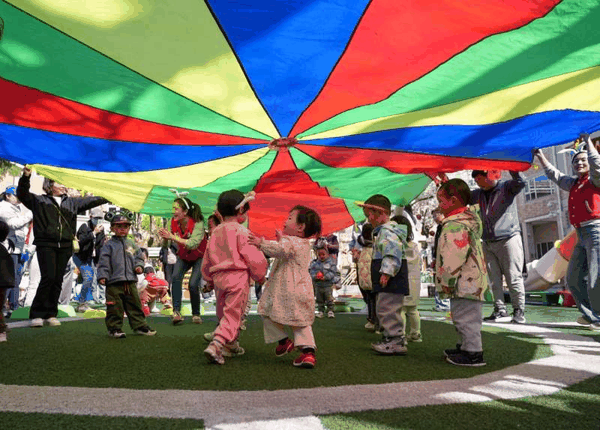 ▲资料图，在某幼儿园亲子托育活动现场，家长和孩子在老师引导下参加户外活动。图/新华社