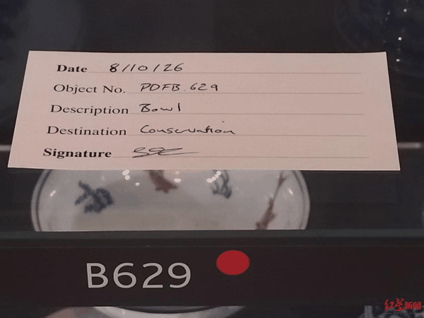 ▲两件受损瓷器原本摆放的位置放上了手写标签，显示瓷器已被送去修复