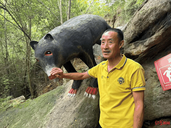 贺昌林向游客们讲解黑熊雕塑的寓意